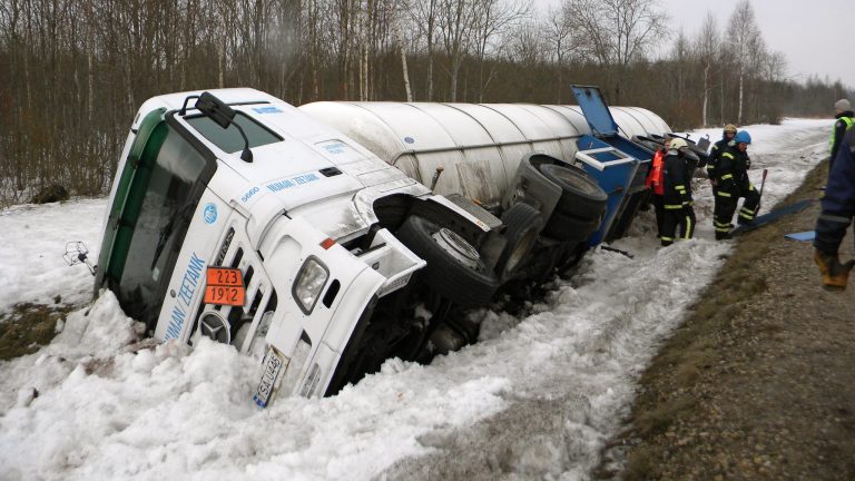 Damaged truck and car at accident scene with rescue services present