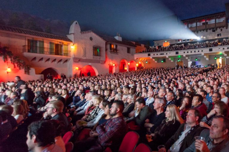 Crowd gathered at the opening of a film festival, people smiling and interacting.